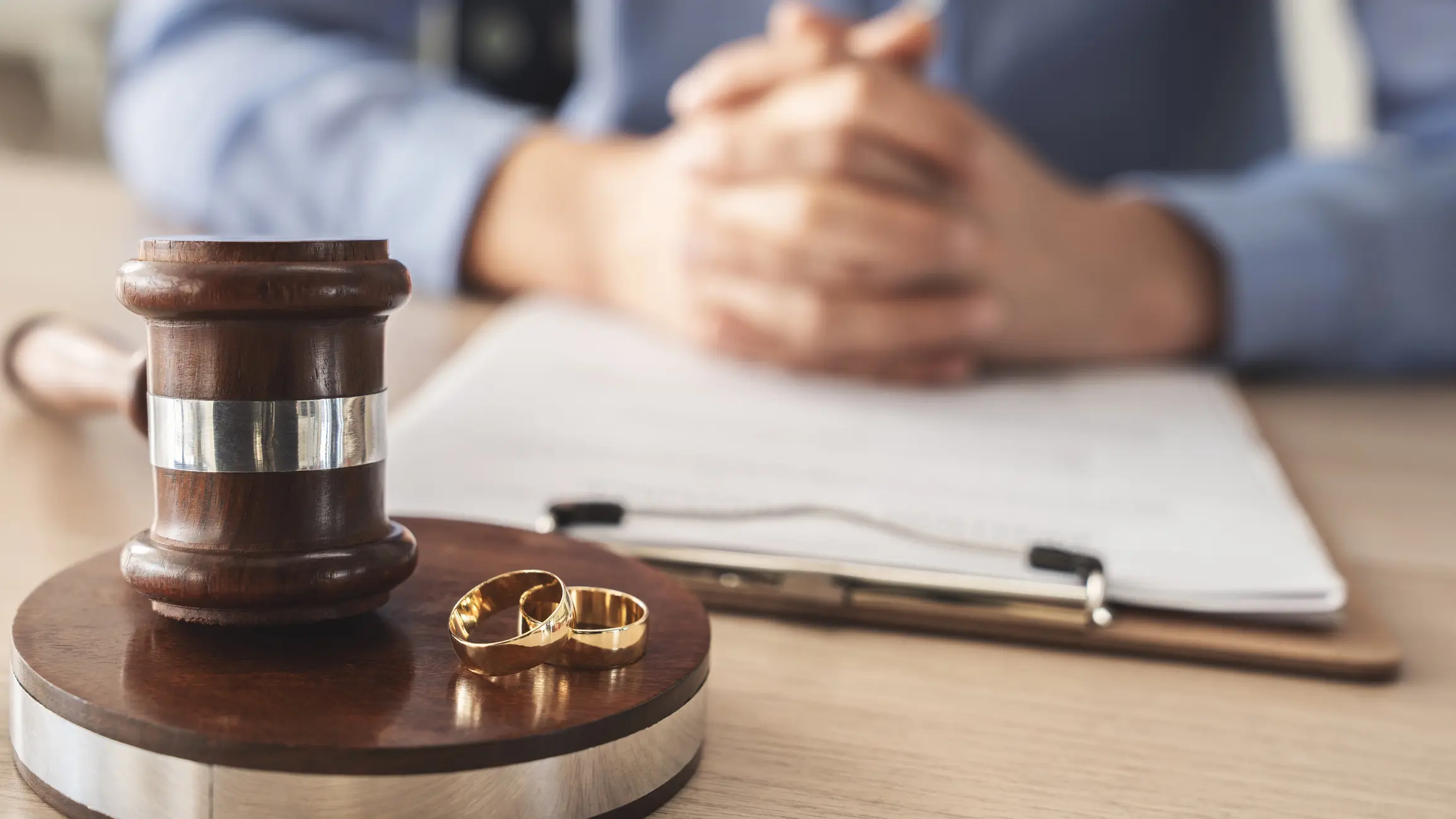 Gavel and wedding rings on table